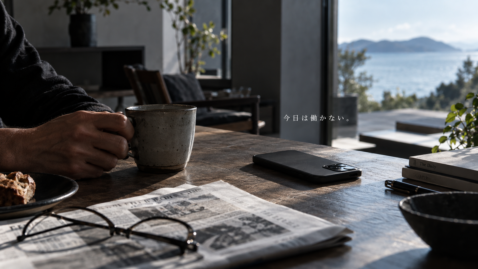平日の朝にスマートフォンを伏せてコーヒーを持つ男性